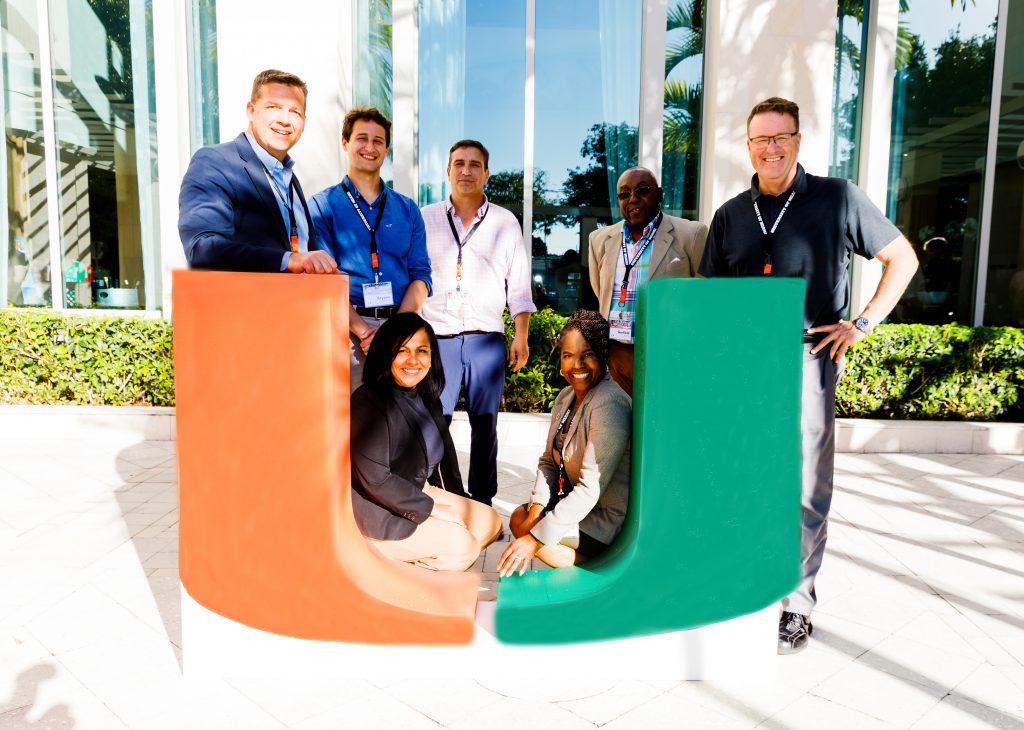 Standing, left to right, Thomas Merrick, Bryson Rudolph, Kim Grinfeder, Garfield Allen, and Justin Gammage, with (seated) Evelyn Cruz and Jacqueline Green-Allen gather at the close of the Miami CR 2025 event at the Newman Alumni Center